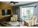 Comfortable living room with wood accent wall, ceiling fan, and sliding glass doors at 2102 Applegate Dr, Ocoee, FL 34761