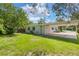 This home's backyard provides a serene outdoor space with lush greenery and a convenient carport, perfect for relaxation at 212 Homewood Dr, Sanford, FL 32773