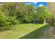 Backyard with mature trees and a partial view of the home at 212 Homewood Dr, Sanford, FL 32773