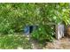 Backyard features storage sheds surrounded by mature trees and lush greenery at 212 Homewood Dr, Sanford, FL 32773