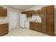 Bright kitchen offers ample storage with wooden cabinets, white appliances, and tile flooring for a clean and efficient cooking space at 212 Homewood Dr, Sanford, FL 32773