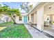 A well-maintained house with a blue door, lush green lawn, and a covered carport at 2417 Cedar Ave, Sanford, FL 32771