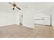 Open-concept living space with tile flooring, ceiling fan, flowing into the kitchen with white appliances at 2417 Cedar Ave, Sanford, FL 32771