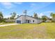 Well-lit single-story house with a gray exterior, a blue front door, and a spacious green lawn at 2506 Sw 158Th Lane Rd, Ocala, FL 34473