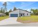 Beautiful single-story home with a modern gray exterior, blue accents, and a spacious front yard at 2506 Sw 158Th Lane Rd, Ocala, FL 34473