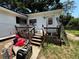 Exterior of home with small porch and stairs to backyard at 25824 Shawnee St, Sorrento, FL 32776