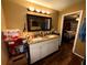 Bathroom featuring granite countertops, dual sinks, and a decorative mirror at 25824 Shawnee St, Sorrento, FL 32776