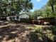 View of the side yard of the home with fencing and some large trashcans at 25824 Shawnee St, Sorrento, FL 32776