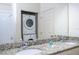 Bathroom with a double sink vanity and granite countertops featuring in-unit laundry at 3229 Cupid Pl, Kissimmee, FL 34747