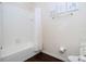 Clean bathroom with a tub and shower, featuring neutral colors and ample space at 3229 Cupid Pl, Kissimmee, FL 34747