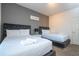 Cozy bedroom with two beds, soft lighting, and a soothing color palette creating a comfortable and inviting space at 3229 Cupid Pl, Kissimmee, FL 34747