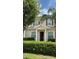 Inviting tan home featuring a covered porch, brown shutters, and manicured landscaping, perfect for comfortable living at 3229 Cupid Pl, Kissimmee, FL 34747