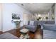 Contemporary living area with sleek gray furniture, dark wood floors, and an open layout leading to the kitchen at 3229 Cupid Pl, Kissimmee, FL 34747