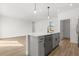 Island kitchen featuring stainless steel appliances, modern pendant lights, and wood-look flooring at 441 Caraway Dr, Kissimmee, FL 34759