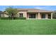 Home exterior shows a manicured lawn, hedge, tile roof, and covered patio at 453 Sorrento Rd, Kissimmee, FL 34759