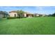 Exterior view of a landscaped backyard with lush green grass and neighborhood view at 453 Sorrento Rd, Kissimmee, FL 34759