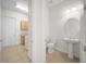 Hallway to half bath and laundry area with tile flooring and neutral paint at 453 Sorrento Rd, Kissimmee, FL 34759
