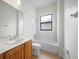 Bright bathroom featuring a vanity, shower-tub combo, and window for natural light at 453 Sorrento Rd, Kissimmee, FL 34759