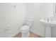 Cozy half bathroom with a pedestal sink, round mirror, and standard toilet at 453 Sorrento Rd, Kissimmee, FL 34759
