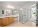 Bright bathroom featuring a glass enclosed shower, tile flooring, and a wooden vanity with sink and large mirror at 453 Sorrento Rd, Kissimmee, FL 34759