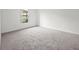 Clean bedroom with soft carpet, trim, and a view of the outdoors through a window at 453 Sorrento Rd, Kissimmee, FL 34759