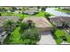 Stunning aerial view of a home with a tile roof, lush landscaping, and a serene lake backdrop at 453 Sorrento Rd, Kissimmee, FL 34759