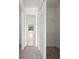 Hallway with carpet flooring leading to a bathroom and featuring closet organizers at 453 Sorrento Rd, Kissimmee, FL 34759