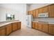 Well-lit kitchen boasts wood cabinets, a refrigerator, and a view of the lush backyard at 453 Sorrento Rd, Kissimmee, FL 34759