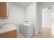 Efficient laundry room with washer, dryer, and storage above a sink, near a hallway at 453 Sorrento Rd, Kissimmee, FL 34759