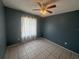 Neutral bedroom with a ceiling fan, tiled flooring, and curtains at 561 Portland Cir, Apopka, FL 32703