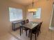 Dining room with glass table and tile floors, next to an open kitchen with pass through at 561 Portland Cir, Apopka, FL 32703
