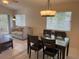 Dining room with tile flooring and glass table, located in an open floor plan next to the living room at 561 Portland Cir, Apopka, FL 32703
