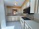 Traditional kitchen features white cabinets, appliances, and a view of the backyard at 561 Portland Cir, Apopka, FL 32703