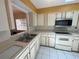 Kitchen featuring white cabinets, a stainless steel microwave, and a double sink at 561 Portland Cir, Apopka, FL 32703