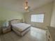 Cozy main bedroom with a ceiling fan, tiled flooring, and a large window at 561 Portland Cir, Apopka, FL 32703