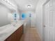 Bright bathroom with double vanity, tiled floor, and unique octagon window for natural light at 612 Doe Cove Pl, Apopka, FL 32703