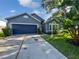 Charming single-Gathering home featuring a blue garage door, landscaped yard, and inviting curb appeal at 612 Doe Cove Pl, Apopka, FL 32703