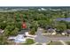 An aerial view of a home with a gray roof, surrounded by trees, with a lake and neighborhood in the distance at 6245 Sleepy Hollow Dr, Orlando, FL 32810