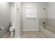 Bright bathroom featuring a toilet, tub and shower combination, a neutral color scheme and bright lighting at 6245 Sleepy Hollow Dr, Orlando, FL 32810