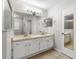 Bright bathroom featuring a dual sink vanity, neutral tile flooring and a large mirror at 6245 Sleepy Hollow Dr, Orlando, FL 32810