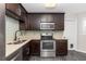 The gourmet kitchen features stainless steel appliances, dark cabinets, and stylish backsplash at 6245 Sleepy Hollow Dr, Orlando, FL 32810