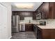 Bright kitchen with stainless steel appliances, mosaic tile backsplash, dark cabinetry and modern fixtures at 6245 Sleepy Hollow Dr, Orlando, FL 32810