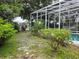 Expansive backyard with a screened enclosure, surrounded by lush landscaping, offers privacy and tranquility at 635 Whitman Cv, Longwood, FL 32750