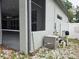 Rear of home featuring utilities and screened in area beyond; all surrounded by mature landscaping at 635 Whitman Cv, Longwood, FL 32750