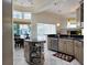 Open kitchen with stainless steel appliances, granite countertops, tiled floor, island, and adjacent breakfast nook at 635 Whitman Cv, Longwood, FL 32750