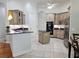 Bright kitchen with stainless steel appliances, granite countertops, tile floor, kitchen island, and bar seating at 635 Whitman Cv, Longwood, FL 32750
