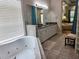 Bright bathroom with a soaker tub, vanity, and access to the bedroom at 635 Whitman Cv, Longwood, FL 32750