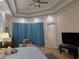 Bright main bedroom with a tray ceiling, carpeted floors, large windows with curtains, and an exterior door at 635 Whitman Cv, Longwood, FL 32750