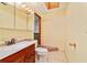 A simple bathroom design features a wooden vanity, tiled flooring and beige walls for a clean functional space at 7024 Harwick Dr, Orlando, FL 32818
