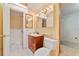 Bathroom with wood vanity, a sink, a toilet, and a framed mirror with decorative lights at 7024 Harwick Dr, Orlando, FL 32818